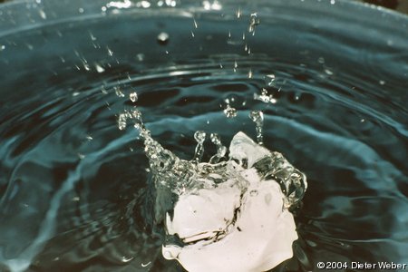 Ein Wassertropfen trifft ein Teelicht